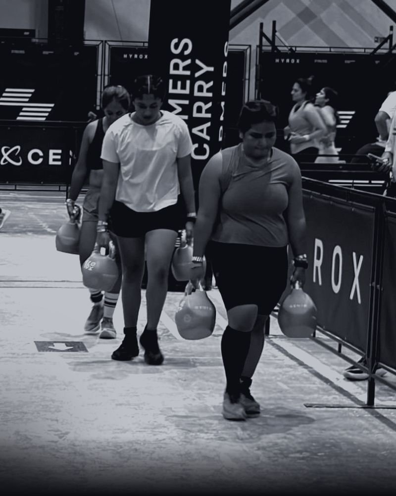 Women on the farmers carry, focused and steady