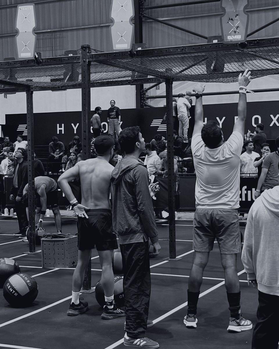 Athletes at the wall-ball station, one reaching for the target